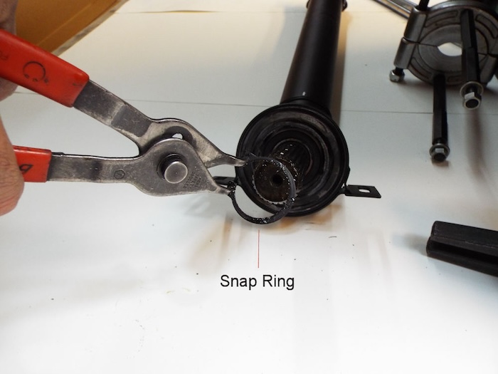 pulling the snap ring located in front of the driveshaft center support